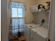 Bright laundry room with washer, dryer, and storage shelves at 5115 44Th St W, Bradenton, FL 34210