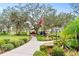 Landscaped front yard with walkway, mature trees, and bird bath at 512 W Venice Ave # 401, Venice, FL 34285