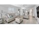 Living room with light beige sofa and ottoman, view into dining area and hallway at 512 W Venice Ave # 401, Venice, FL 34285