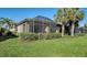 Screened lanai with lush landscaping and grassy backyard at 5846 Cavano Dr, Sarasota, FL 34231
