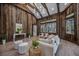 Relaxing living area with wood walls, large windows, and stylish furniture at 6200 Saddle Oak Trl, Sarasota, FL 34241