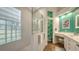 Modern bathroom with walk-in shower, double vanity, and teal feature wall at 6523 Virginia Xing, University Park, FL 34201
