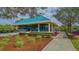 Community clubhouse with teal roof and landscaping at 6523 Virginia Xing, University Park, FL 34201