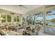 Bright sunroom with lake views, wicker furniture, and access to a patio at 6525 Berkshire Pl, University Park, FL 34201
