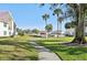 Paved walkway next to grassy area and community pool at 760 Village Cir # 109, Venice, FL 34292