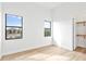 Bright bedroom with wood-look floors, two windows, and a walk-in closet at 8367 Sea Glass Ct, Sarasota, FL 34240