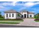 Modern two-story home with a paver driveway and tropical landscaping at 8367 Sea Glass Ct, Sarasota, FL 34240