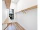 Walk-in closet features wood shelving, hardwood floors, and a window for natural light at 8367 Sea Glass Ct, Sarasota, FL 34240