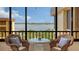 Relaxing balcony with wicker chairs and table overlooking the water at 8779 Midnight Pass Rd # 504H, Sarasota, FL 34242