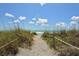 Sandy pathway leads to the beach, lined with sea grass and a rope fence at 8779 Midnight Pass Rd # 504H, Sarasota, FL 34242
