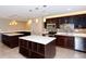 Modern kitchen featuring dark wood cabinets, stainless steel appliances, and a large island at 8779 Midnight Pass Rd # 504H, Sarasota, FL 34242