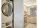 Stackable washer and dryer in a well-lit laundry room with kitchen access at 8779 Midnight Pass Rd # 504H, Sarasota, FL 34242