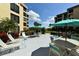 Community patio with tables, chairs, and grills at 8779 Midnight Pass Rd # 504H, Sarasota, FL 34242