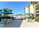 Community pool area with patio tables and chairs for relaxing at 8779 Midnight Pass Rd # 504H, Sarasota, FL 34242