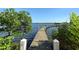Serene waterfront view with a long wooden dock extending into the water at 8779 Midnight Pass Rd # 504H, Sarasota, FL 34242