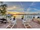 Waterfront patio with chairs and a view of the sunset at 174 Golden Gate Pt # 11, Sarasota, FL 34236