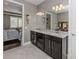 Double vanity bathroom with dark brown cabinets and view of bedroom at 19696 Petrino St, Venice, FL 34293