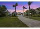 Two-story home with a long driveway and palm trees at 2115 Lychee Ln, Nokomis, FL 34275