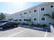 Shell Cove building exterior, featuring light teal walls and ample parking at 2310 Gulf N Dr # 205, Bradenton Beach, FL 34217