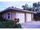 Two-car garage with white doors and landscaping at 2426 Nassau St, Sarasota, FL 34231
