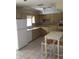 Small kitchen with yellow cabinets, a white refrigerator, and a small table at 2426 Nassau St, Sarasota, FL 34231