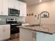 Stainless steel appliances and granite countertops in modern kitchen at 2769 Emory Sound Pl, Brandon, FL 33510