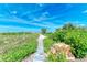 Beach access walkway with lush landscaping and stone accents at 506 S Casey Key Rd, Nokomis, FL 34275