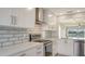 Modern kitchen with white cabinets, stainless steel appliances, and tile backsplash at 5218 Wedgewood Ln # 72, Sarasota, FL 34235