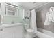 Clean bathroom with white vanity, shower/tub combo, and gray tile at 5955 Midnight Pass Rd # 4E, Sarasota, FL 34242