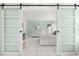 Bedroom with white sliding barn doors and a view into the bedroom at 5955 Midnight Pass Rd # 4E, Sarasota, FL 34242