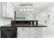 Modern kitchen with dark granite counters and white cabinets at 5955 Midnight Pass Rd # 4E, Sarasota, FL 34242