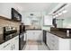 Modern kitchen with white cabinets, granite counters & stainless steel appliances at 5955 Midnight Pass Rd # 4E, Sarasota, FL 34242
