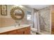 Bathroom with wood vanity, large mirror, and updated tile shower at 8440 Midnight Pass Rd, Sarasota, FL 34242