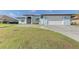 Light blue house with white garage door and landscaping at 9150 Melody Cir, Port Charlotte, FL 33981