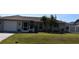 House with a gray exterior, palm trees, and a fenced backyard at 9359 Casa Grande Ave, Englewood, FL 34224