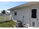 Side view of home with AC unit and fenced yard at 9359 Casa Grande Ave, Englewood, FL 34224