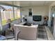 Relaxing screened porch with wicker furniture, a TV, and a cat tree at 9359 Casa Grande Ave, Englewood, FL 34224