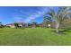 Large grassy backyard with tropical landscaping and home view at 10656 Glencorse Ter, Bradenton, FL 34211