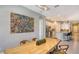 Open concept dining room with a live-edge wood table and artwork at 10656 Glencorse Ter, Bradenton, FL 34211