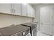 Bright laundry room with modern washer, dryer, and ample storage at 10656 Glencorse Ter, Bradenton, FL 34211