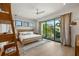 Bright bedroom with a queen bed, wooden shelving, and access to a balcony at 112 Maple Ave, Anna Maria, FL 34216