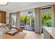 Bright dining area with view of balcony and tropical landscape at 112 Maple Ave, Anna Maria, FL 34216