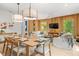 Bright dining room with a large wooden table and modern light fixtures at 112 Maple Ave, Anna Maria, FL 34216