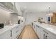 Modern kitchen with white cabinets, quartz countertops and stainless steel appliances at 112 Maple Ave, Anna Maria, FL 34216