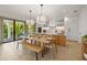 Modern kitchen with light wood cabinets, island, and dining area at 112 Maple Ave, Anna Maria, FL 34216