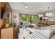 Open-concept living space with modern sofas and access to outdoor balcony at 112 Maple Ave, Anna Maria, FL 34216