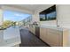 Outdoor kitchen with grill, sink, and large TV at 112 Maple Ave, Anna Maria, FL 34216