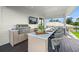 Outdoor kitchen with grill, bar seating, and granite countertops at 112 Maple Ave, Anna Maria, FL 34216