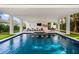 Modern pool and patio with a covered lounging area at 112 Maple Ave, Anna Maria, FL 34216