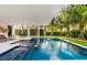 Relaxing pool area with a covered patio and lounge chairs at 112 Maple Ave, Anna Maria, FL 34216